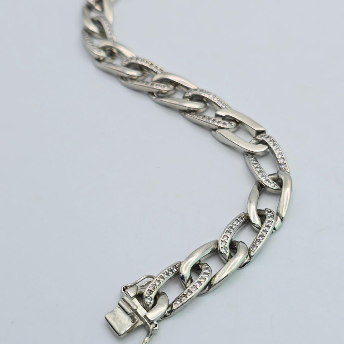 Silver chain bracelet on a light gray background