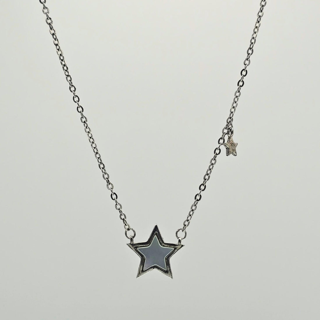 Star-shaped pendant necklace on a light gray background