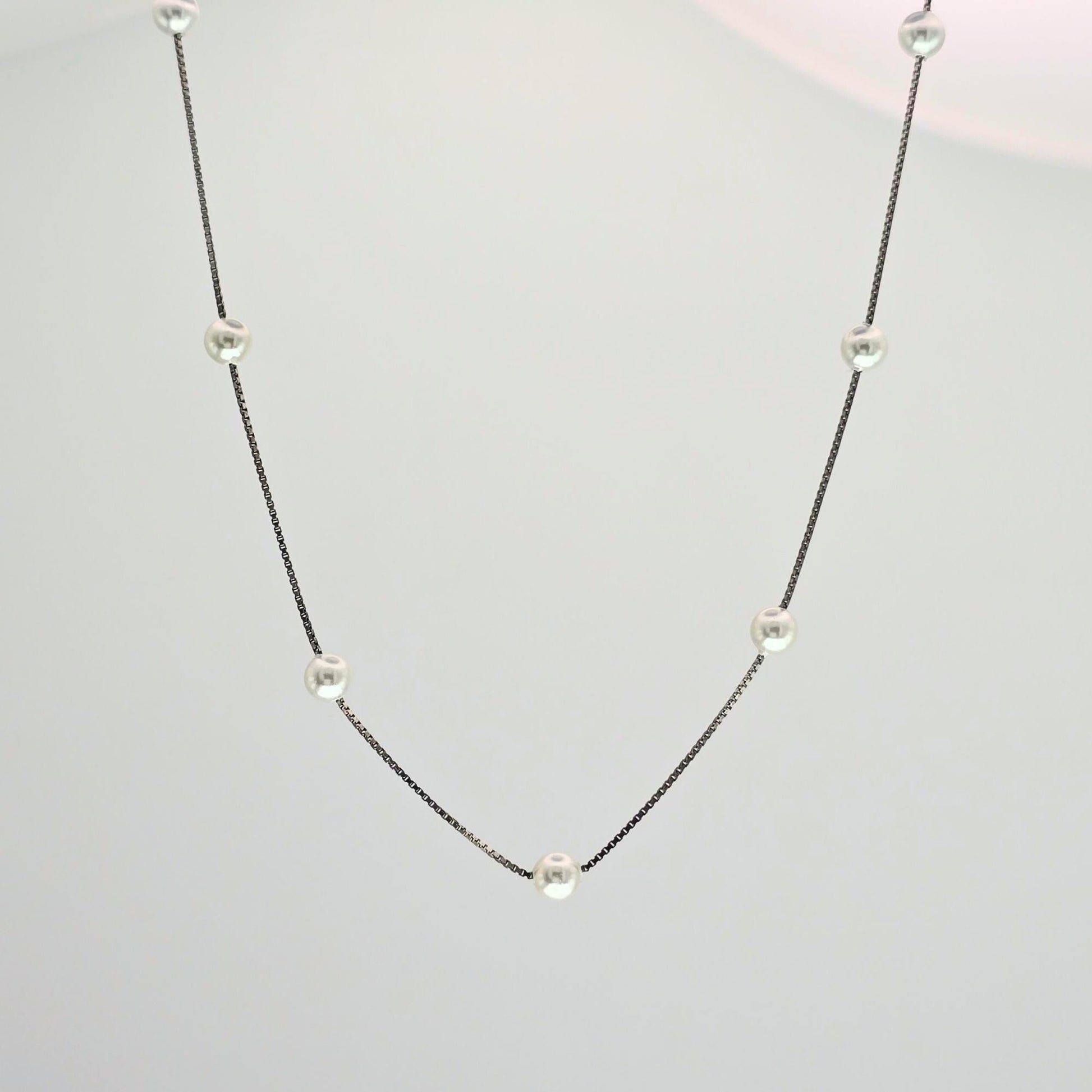 Necklace with small pearls on a light gray background