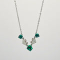 Necklace with green gemstones and silver pendants on a white background