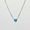 Heart-shaped blue gemstone necklace on a light gray background