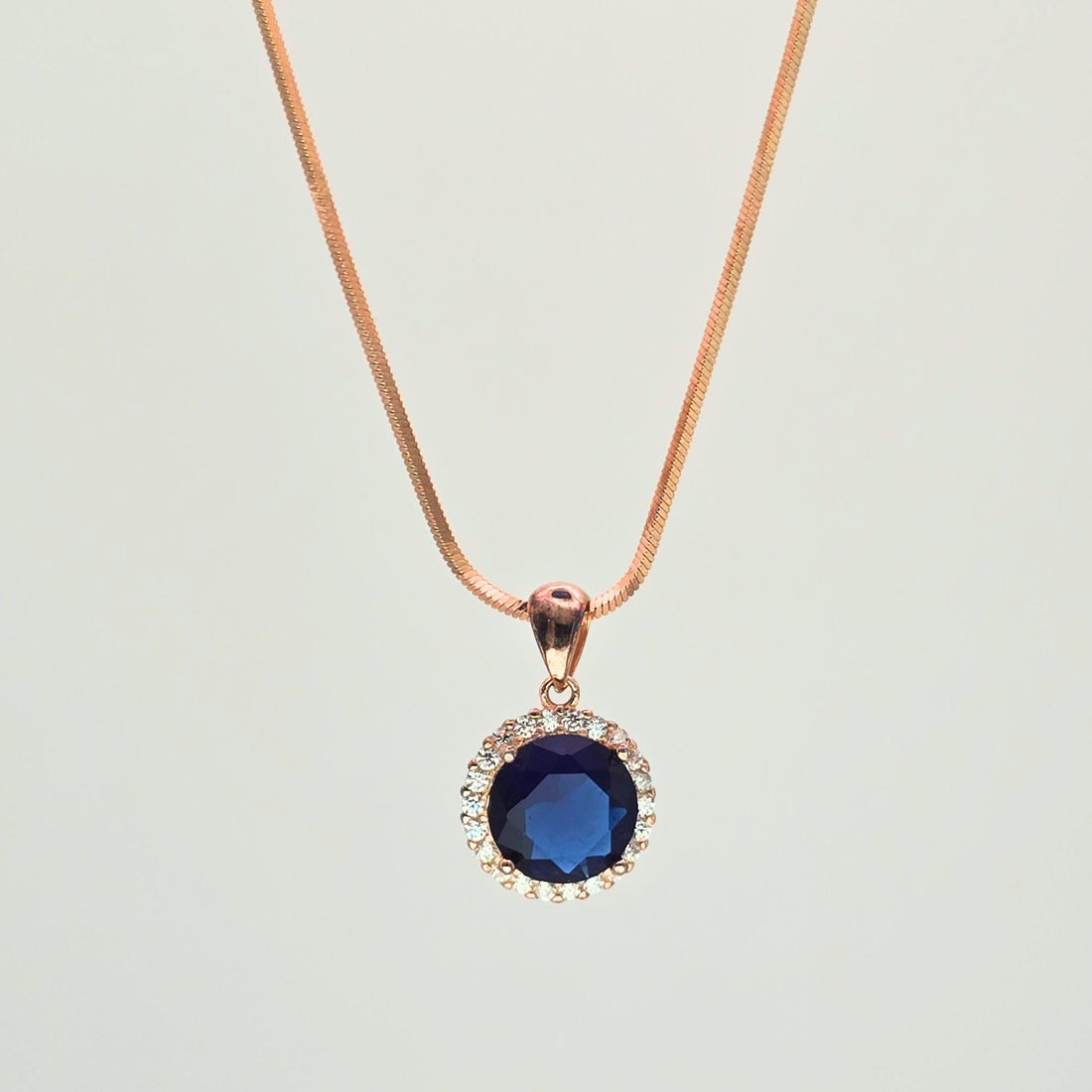 Necklace with a blue pendant on a light gray background