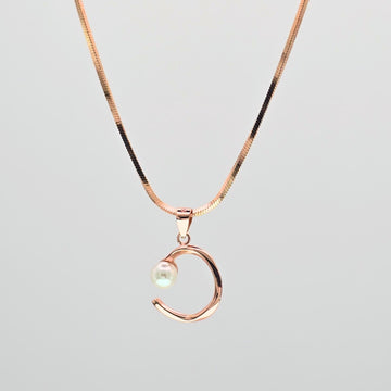 Rose gold necklace with a crescent moon pendant on a light gray background