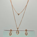 Rose gold necklace and earrings on a gray background
