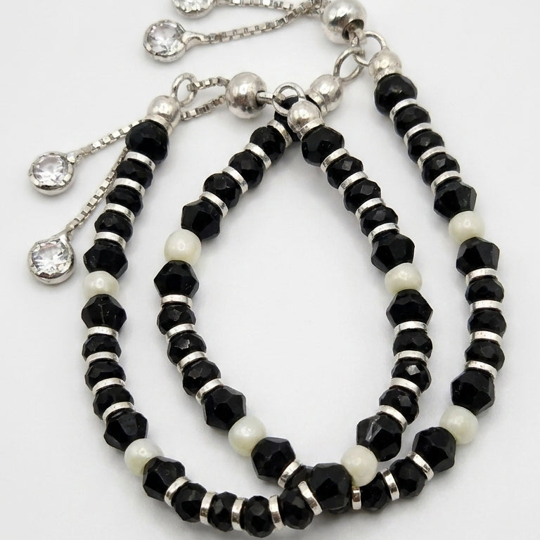 Set of black and white beaded necklaces with silver clasps on a white background