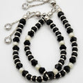 Set of black and white beaded necklaces with silver clasps on a white background